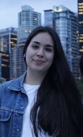 Photography of Emily Riddle. She has long black hair and is wearing a white shirt and a blue denim jacket. 